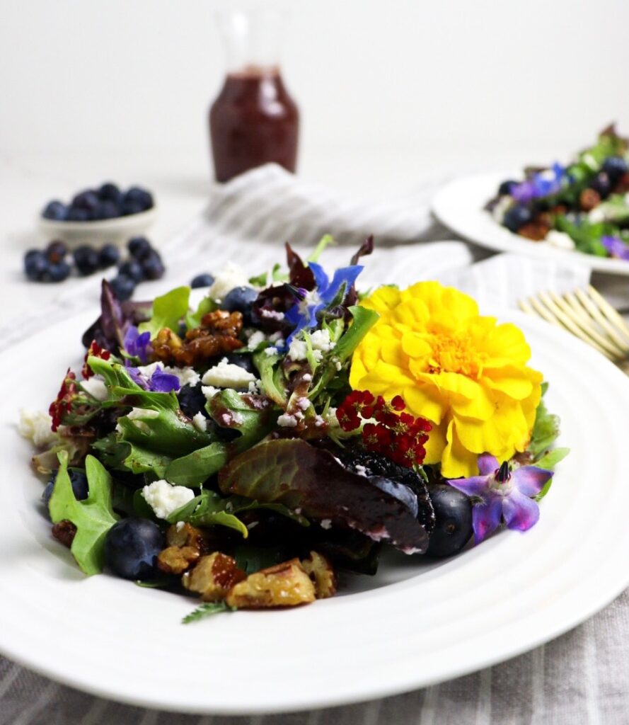 Plate of blueberry salad with side of maple blueberry balsamic vinaigrette