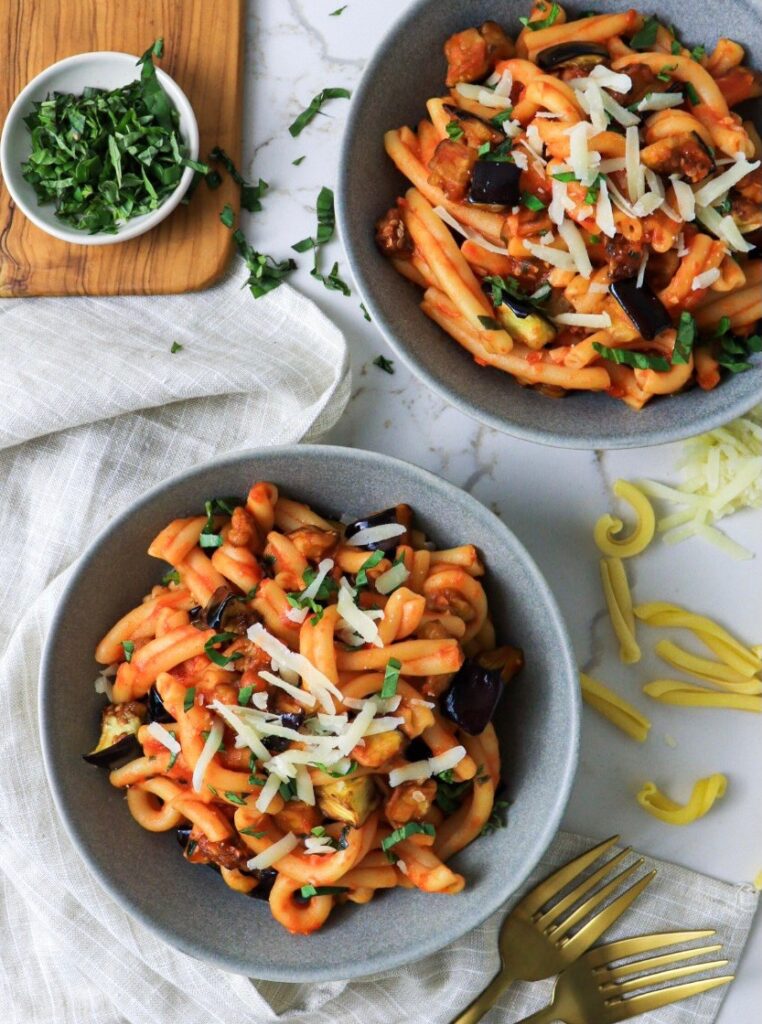 Two bowls of pasta alla norma with casarecce pasta