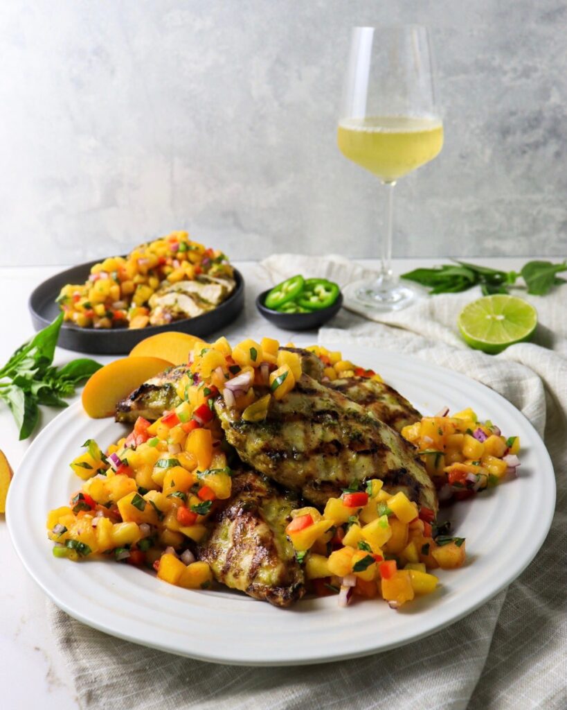 Plate of basil lime chicken and peach salsa with white wine pairing