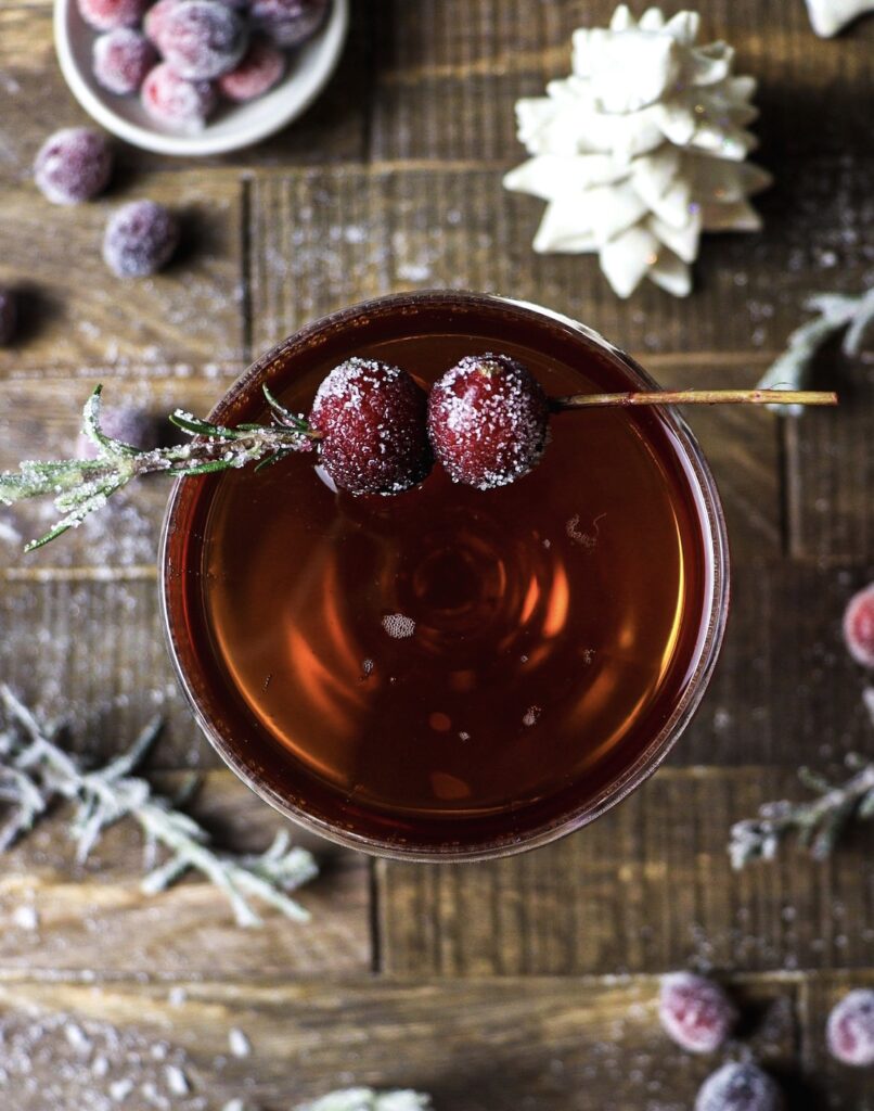 Christmas cocktail with sugared cranberries garnish